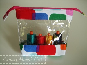 A clear vinyl pouch with colourful fabric accents