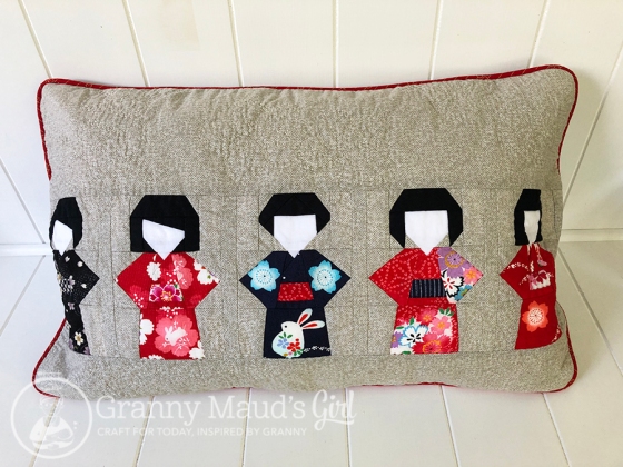 Cushion featuring patchwork kokeshi dolls